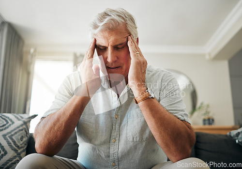 Image of Senior man with headache, stress or anxiety about retirement, financial problem or house mortgage in his living room. Sick elderly man with migraine pain or mental health risk and frustrated on sofa