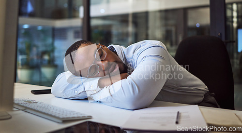 Image of Black man in business, tired and sleeping on night office desk after programming computer code, database seo or cybersecurity. Burnout, exhausted and sleepy worker with documents deadline in Nigeria