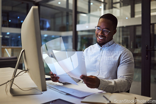 Image of Documents, night and computer with a businessman working at his desk late in the office. Paperwork, finance and tax with a male employee at work for overtime on a deadline while reading a report