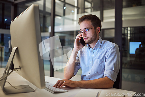 Image of Business, communication and overtime, phone call and man with computer at desk. Late night at office, working on deal or project. Corporate worker in glasses, typing online and talking on smartphone.