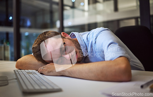 Image of Night sleep, business burnout and businessman sleeping at his desk in his dark office at work. Tired corporate employee, worker or manager with stress taking a nap at a table while working overtime