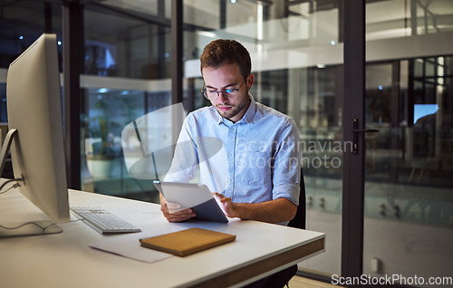 Image of Business, communication and overtime, man with tablet and computer at desk. Late night at office, working on deal or internet project. Corporate worker in glasses, checking online financial report.