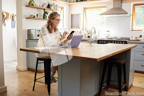 Image of Woman, phone and kitchen smile for social media, email or text while work online. Mature, lady and smartphone with laptop for communication in remote job on web, laughing at meme or joke on cellphone