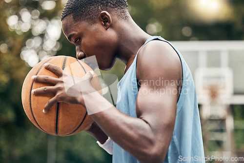 Image of Sports, fitness and man with a kiss to a basketball in training, workout and athletic exercise outdoors. Culture, wellness and young player or athlete with passion and love for playing on court