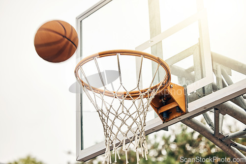Image of Basketball, net and ball flight in sports game outdoors for match in the USA. Sport and airball of throw to score point for win, victory against fiberglass board outside in a urban town or courtyard