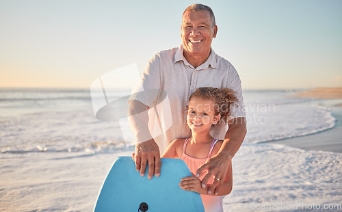 Image of Beach, grandfather and girl learning to surf from a happy senior man in her family on a summer holiday outdoors. Smile, sports and old man teaching or training a child surfing on a board in the ocean