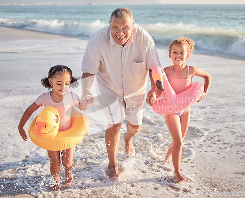 Image of Children, beach and family with a girl, grandfather and sister playing on the sand by the sea or ocean in summer. Water, travel and fun with a grandparent, grandchild and sibling outdoor on holiday