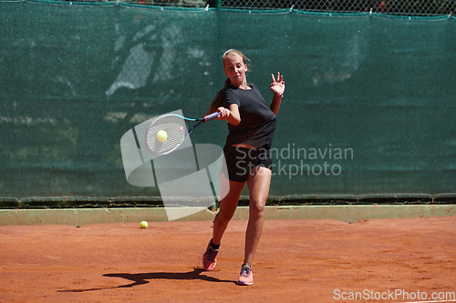 Image of A young girl showing professional tennis skills in a competitive match on a sunny day, surrounded by the modern aesthetics of a tennis court.