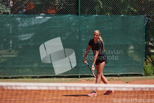 Image of A young girl showing professional tennis skills in a competitive match on a sunny day, surrounded by the modern aesthetics of a tennis court.