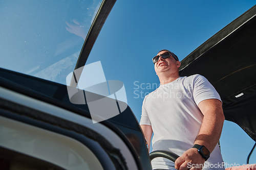 Image of Man on luxurious yacht on the open sea, relaxing in the warmth of the sun, as they enjoy a day filled with adventure and friendship.