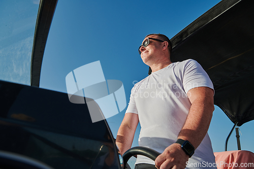 Image of Man on luxurious yacht on the open sea, relaxing in the warmth of the sun, as they enjoy a day filled with adventure and friendship.