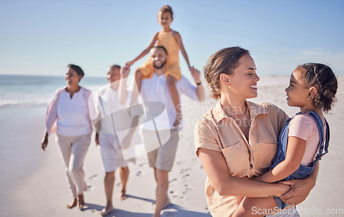 Image of Mother and child on holiday by the beach with grandparents taking a walk together. A happy big family walking by the sea and mom and dad carrying kids. Summer, vacation and family fun by the ocean