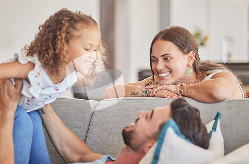 Image of Mom, kid and father playing on sofa lounge at family home in Colombia for love, care and quality time together. Smile parents, excited laughing child and relax living room for fun, happiness and joy