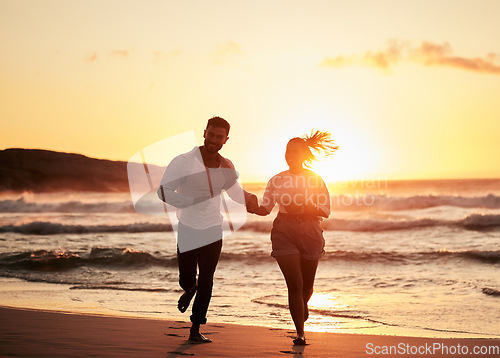 Image of Ocean, holiday and sunset, running couple on beach happy holding hands. Love, romance and man and woman run in evening sun. Romantic vacation, spend time together and playing in nature and fun at sea