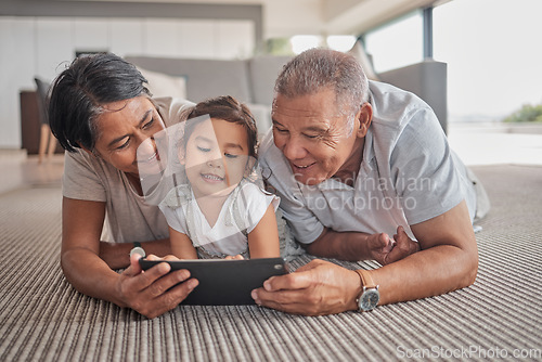 Image of Relax, grandparents and cartoon on tablet with child on home floor together in the Philippines. Filipino family bonding time with grandfather, grandmother and grandchild watching animation online.