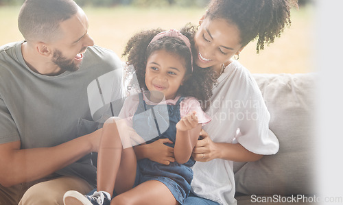 Image of Love, relax and happy family laughing on a sofa, bonding and playing in living room together. Fun, cheerful and caring parents enjoy game with little girl, quality time and happiness by black family