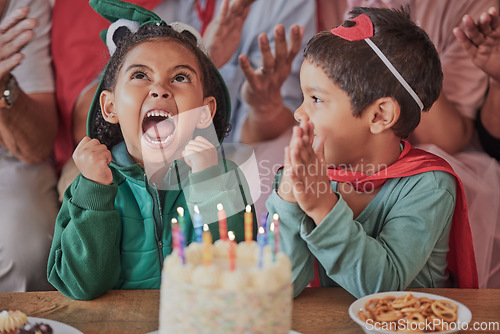 Image of Happy birthday, party and children in halloween costume to celebrate young and fun girls special day together. Cake, fantasy and excited kid in a dinosaur monster outfit and boy in a superheroes cape