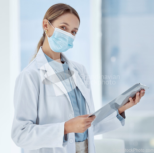 Image of Doctor with covid face mask and a checklist for compliance, risk management and medical insurance. Portrait of a healthcare woman expert with corona virus innovation planning in a hospital or clinic