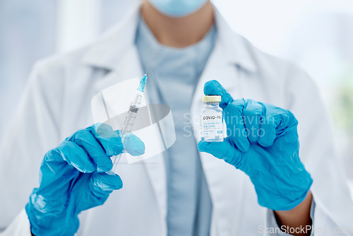 Image of Covid, vaccine and hands of a medical doctor holding the needle and syringe for an injection. Medicine, science and closeup of healthcare worker with a pharmaceutical virus treatment in a glass vial.