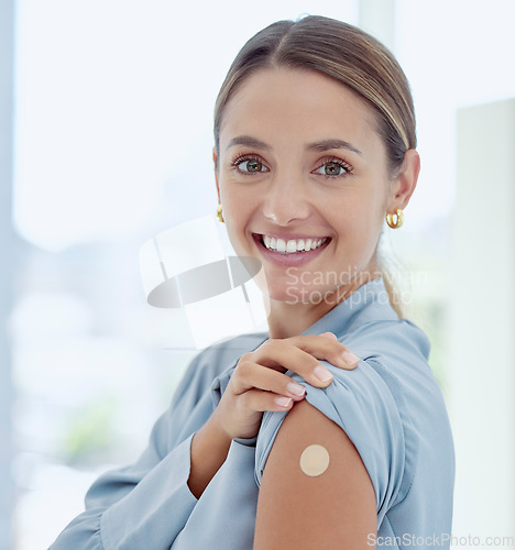 Image of Portrait of woman with a plaster on her arm from vaccine or an injection. Young, smiling woman with patch near her shoulder from getting vaccinated. Prevention, cure and immunity from covid or virus