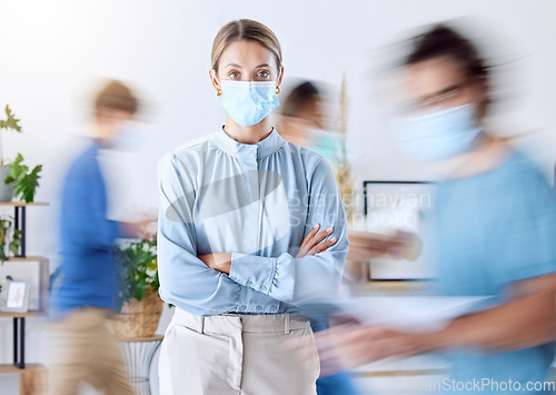 Image of Portrait of business woman in office during covid and a blur of people in the office. Business people, compliance and wearing face mask for safety. Female leader working in busy fast pace workplace