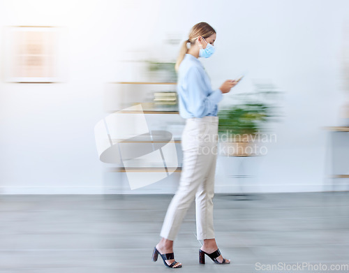 Image of Covid mask in office, woman walking with phone doing business in fast pace workplace with protection and typing email. Professional employee safety in corona virus, company healthcare and busy blur