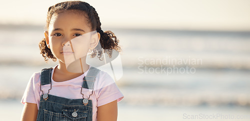 Image of Portrait of girl child on holiday, at beach and standing in the sun by the ocean. Kid on summer holiday, travel to the coast in the sunshine and sand. Toddler by sea, childhood memory and on vacation