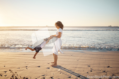 Image of Mother, girl spinning and family at the beach playing together in the sunshine. Mom and young fun child in summer sunlight bonding at sea water waves and beach sand feeling happy outdoor on vacation
