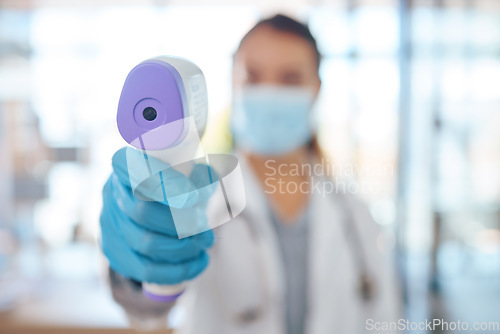 Image of Hand, woman doctor and covid test thermometer laser gun for medical exam, check or covid 19 scan at vaccine center. Healthcare nurse, mask and glove for corona virus safety and protection at clinic