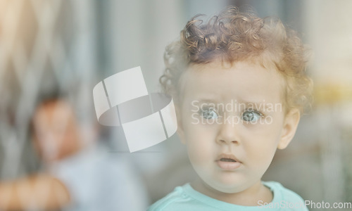 Image of Baby, eyes and safety at window curious with wonder on face in home, toddler and looking in distance alone. Child or boy thinking with thoughtful expression, for danger and left unattended in house