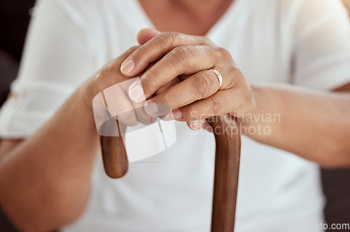 Image of Hands of an elderly woman on a walking cane in a disability nursing or retirement home. Closeup of a disabled senior lady sitting with her stick at a wellness, healthcare or physical therapy center.