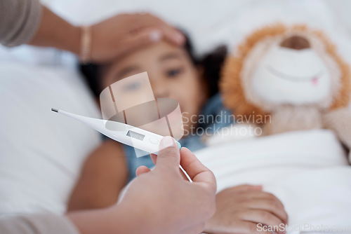 Image of A child in bed with covid, a fever and thermometer showing temperature. Mother with sick kid with hand on head to check if it is hot or cold. Ill with flu, healthcare and medical care in family home