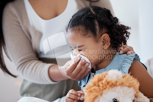 Image of Mother clean sick child nose with tissue, playing with toy or teddy bear in bedroom at family home. Teacher at kindergarten use toilet paper, to help clean young girl face after sneeze or runny nose