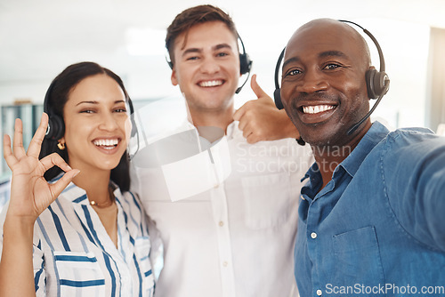 Image of Woman, men and selfie of call center agents with headset, thumbs up and ok. Teamwork, support and help, friendly, excited telemarketing or crm team. Group of happy customer service consultant smiling