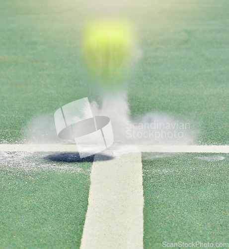 Image of Tennis, sport and training with a ball on a court bouncing during a game to score a point or winner. Sports, scoring and boundary with a match playing on a field with chalk and artificial grass