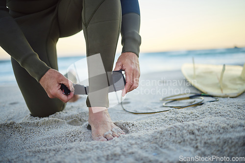 Image of Foot, with surfboard and leash on sand prepare to enter sea, on beach and to relax on holiday, vacation and wet suit. Surfing, healthy man and ready to surf ocean for wellness and health on seaside.