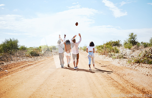 Image of Summer, adventure and friends walking on dirt road in the country, throwing ball in air. Travel, freedom and young group of men and women on holiday together to explore nature, vacation and blue sky