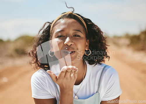 Image of Happy woman, blowing kiss and portrait for love emoji, relax and flirting outdoors in Colombia. Young, smile and freedom gen z girl with expression of hand kisses, joy and summer happiness in nature