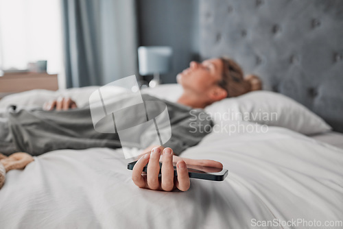 Image of Phone, bed and woman sleeping in a bedroom, exhausted and suffering with mental health problem. Tired, lazy and procrastination by depressed lady ignoring alarm, experience fatigue from insomnia
