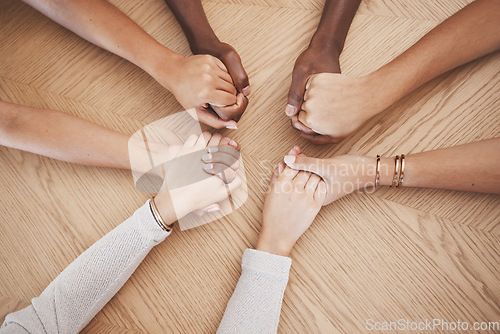 Image of Diversity, people holding hands and support for trust and relationship for unity, commitment and community. Group of diverse hand in teamwork collaboration and multiracial respect on a wooden table