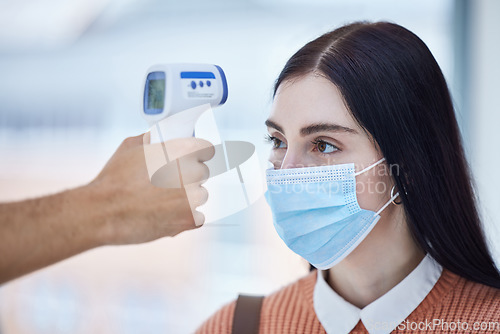 Image of Thermometer, healthcare and covid with a doctor scan a patient temperature with infrared, checking for a fever. Sick woman with mask for corona, flu or cold in exam or consult in a medical clinic