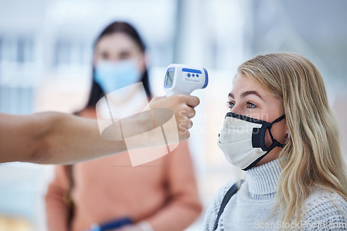 Image of Covid, travel and safety thermometer security test at airport for healthcare protocol inspection. Travelling woman with face mask for coronavirus fever check with medical screening worker.