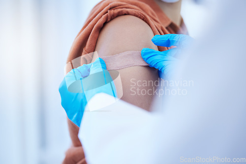 Image of Doctor hand, covid vaccine and plaster on patient for virus protection or illness prevention. Medical professional, health care worker and place bandage on arm wound after vaccination injection
