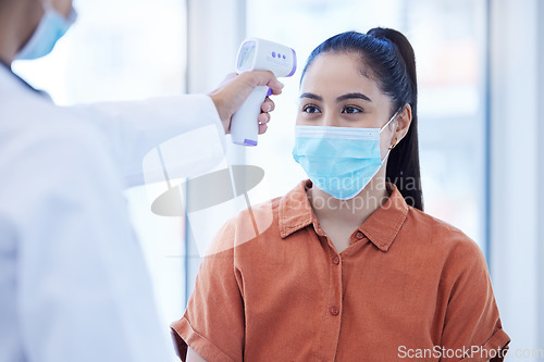 Image of Covid doctor check woman thermometer for fever, sickness and flu test analysis in clinical surgery. Face mask patient, forehead laser and healthcare consulting corona virus safety in medical hospital