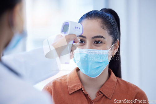 Image of Doctor, patient and covid thermometer check on woman for office, business or building entry. Corona testing protocol, screening requirements and mask on face for illness prevention or protection