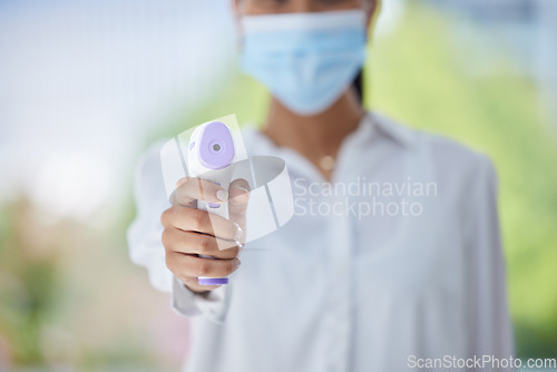 Image of Covid, hand and health thermometer in office, healthcare or wellness check from a employee. Woman work with medical equipment to document fever for disease, dengue fever or corona scan at a workplace