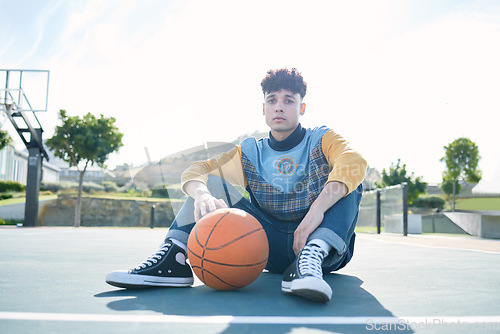 Image of Man, basketball and training sitting on basketball court for rest, relax or breathe during practice. Basketball player, workout and sports for game in park for sport, fitness and physical health