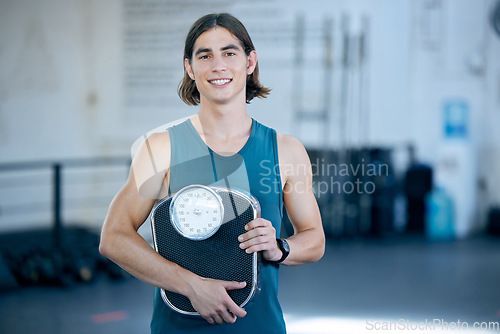 Image of Fitness, exercise and weight scale with a sports man in the gym for training, workout or weightloss. Health, wellness and motivation with a male athlete in a club for exercising or staying active