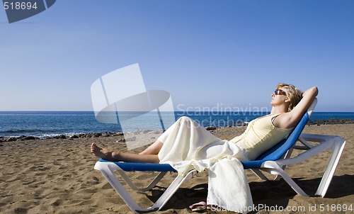 Image of woman resting on the beach in the summer