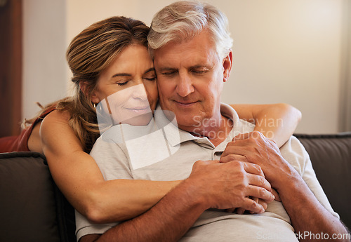 Image of Hug, love and senior couple giving support during retirement in the living room of their house. Happy elderly man and woman hugging in trust, help on sofa and happiness together in their home